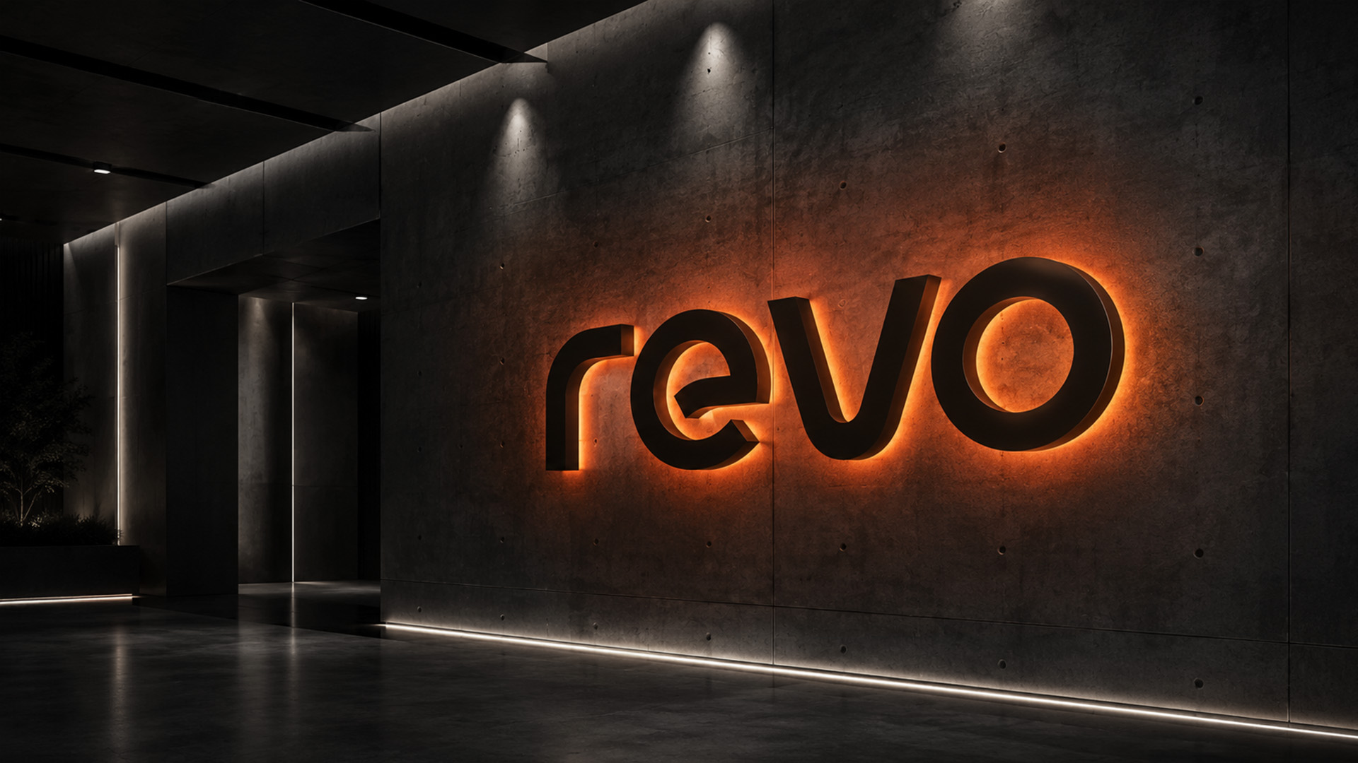 The illuminated REVO wordmark on a dark architectural wall, from the original brand collection
